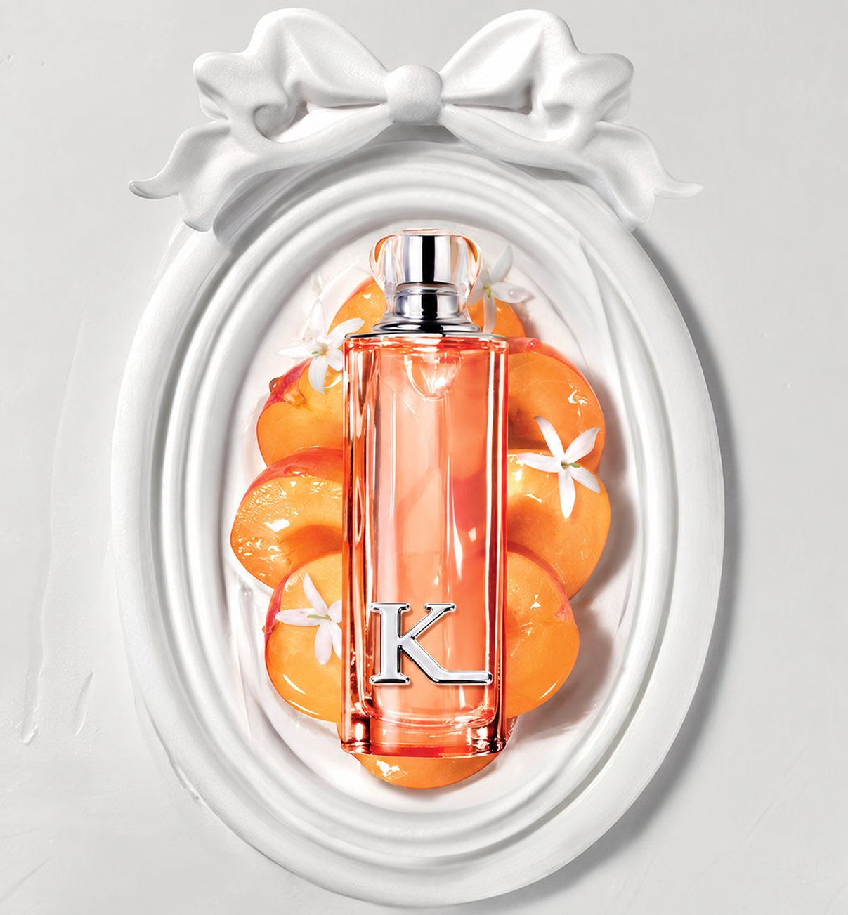 Kissing Light Peachy Glow bottle with peach, flowers and an oval frame